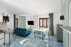 Una cocina moderna con comedor, sofá y televisión.