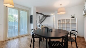 A modern dining area with a round table, black chairs, and pendant lights. - Villa 'Le Golfette Ville Al Golf 2' with Private Pool, Private Terrace and Wi-Fi (Manerba del Garda)
