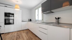 A modern kitchen with white cabinets, a stainless steel oven, and a wooden floor. - Villa 'Le Golfette Ville Al Golf 2' with Private Pool, Private Terrace and Wi-Fi (Manerba del Garda)