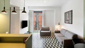 A modern living room with a sofa, a TV, and a patterned floor. - Apartment 'Superior In Via Toledo' with Balcony, Wi-Fi and Air Conditioning (Napoli)