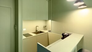 A compact kitchen with a sink, countertop, and pendant lighting. - Apartment 'Superior In Via Toledo' with Balcony, Wi-Fi and Air Conditioning (Napoli)