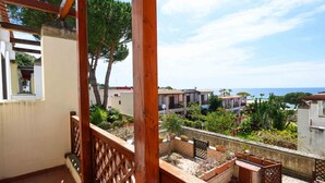 A balcony with a wooden railing, a view of a coastal area, and potted plants. - Villa 'With Pool in Private Park' with Sea View, Wi-Fi and Air Conditioning (Agnone Cilento)