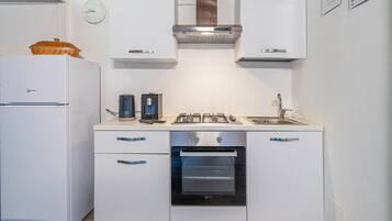 Een koelkast, een oven, een kookplaat, een koffiezetapparaat/waterkoker