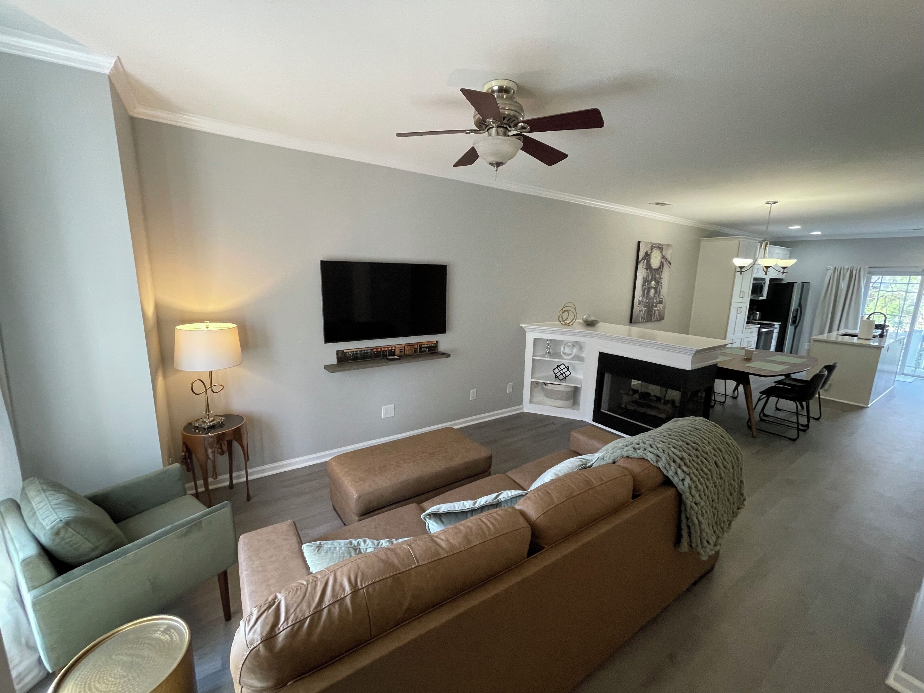 Ein modernes Wohnzimmer mit einer großen Couch, einem Fernseher und einem Kamin.