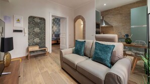 Una sala moderna con un sofá, una mesa de centro y una zona de comedor con mesa y sillas.