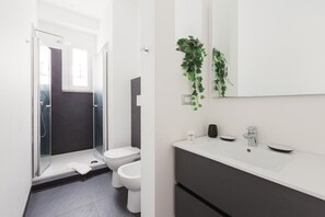 Een douche, een haardroger, een bidet, handdoeken