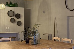 A dining area with a wooden table, chairs, and decorative items including vases and plates.