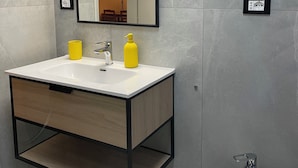 Ein modernes Badezimmer mit einem weißen Waschbecken, einem Spiegel und einem Bidet.