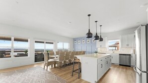 A spacious kitchen with a large island, modern appliances, and a view of the outdoors.