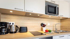 Une cuisine moderne équipée d’un four à micro-ondes, d’une machine à café et d’un four.