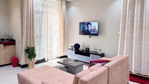 A modern living room with a sofa, a coffee table, and a TV mounted on the wall.