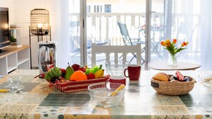Une table à manger avec un panier de fruits, un saladier et un panier de pain.