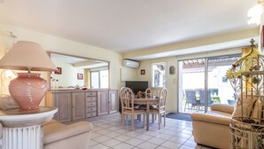 A spacious living area with a dining table, chairs, a sofa, and a decorative lamp. - Domaine Grand Plage by Interhome (Cap d'Agde)