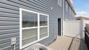 A residential building with a deck, a large window with blinds, and a white fence. - Raceday Getaway, 3BR/2.5BA home right across from Bristol Motor Speedway! (Bristol)