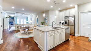 A spacious kitchen with a large island, white cabinetry, and stainless steel appliances. - Swim, Hike & Chill: Spacious Ocean View Townhome! (Ocean View)