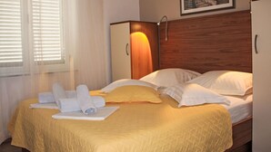 Un lit bien fait, avec une couvre-lit jaune, des oreillers blancs et des serviettes enroulées.