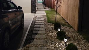A residential driveway leading to a garage with a car parked on the left. - Your Elegant Escape | Newly Built Prescott Private Suite (Spruce Grove)
