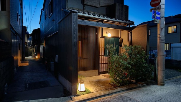A traditional Japanese-style building with a wooden exterior, a small entrance, and a lantern outside. - Ayanishiki Shimabara-Omon Residence (Kyoto)