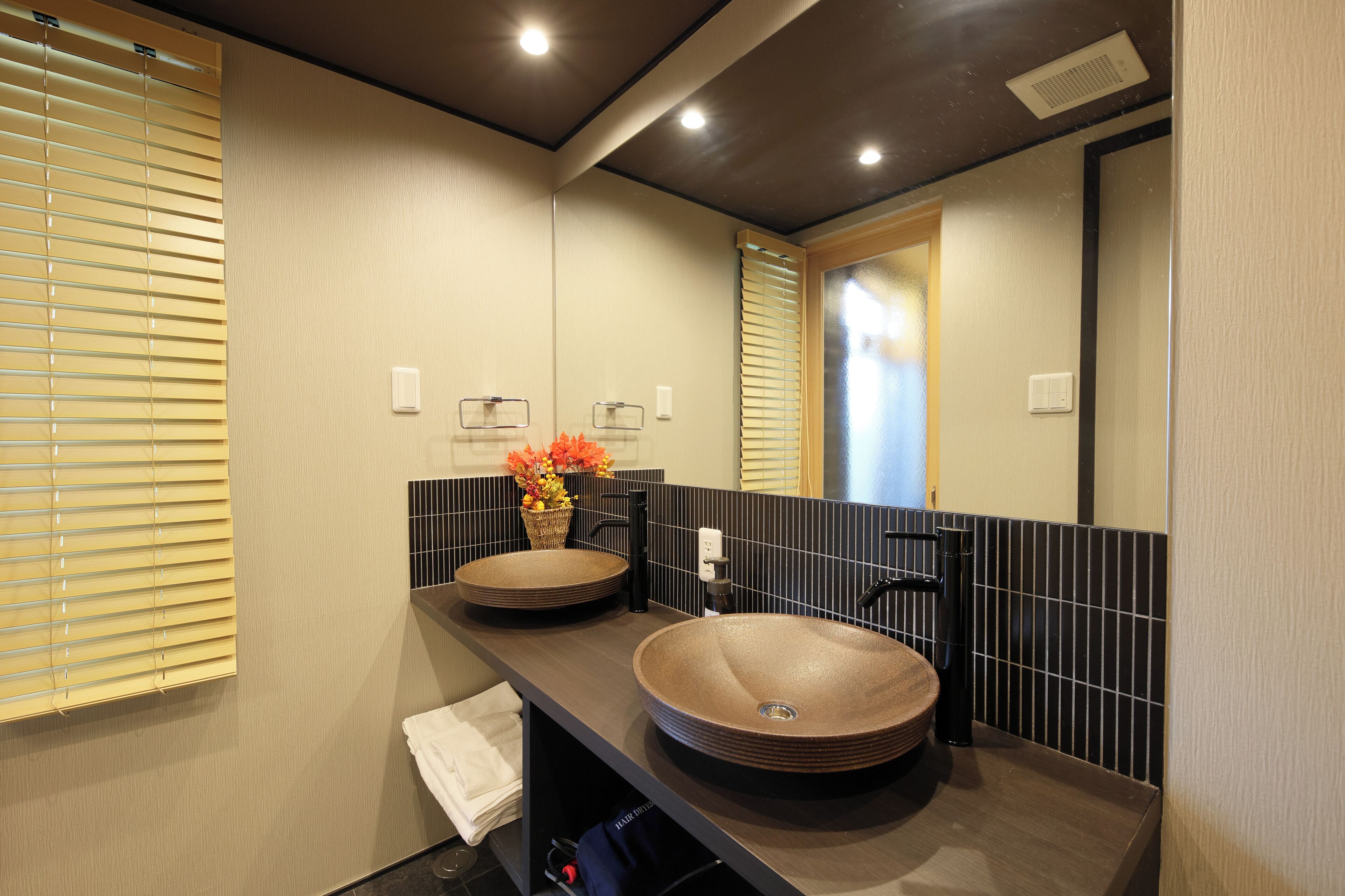 Une salle de bain moderne avec deux vasques rondes, un miroir et un porte-serviettes.