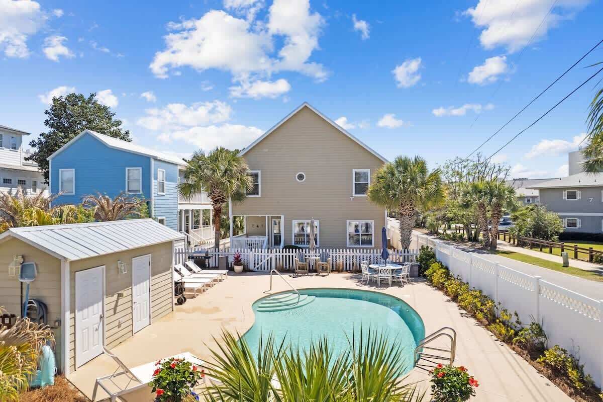 Propiedad residencial con piscina, patio cercado y valla de piquetes blancos.