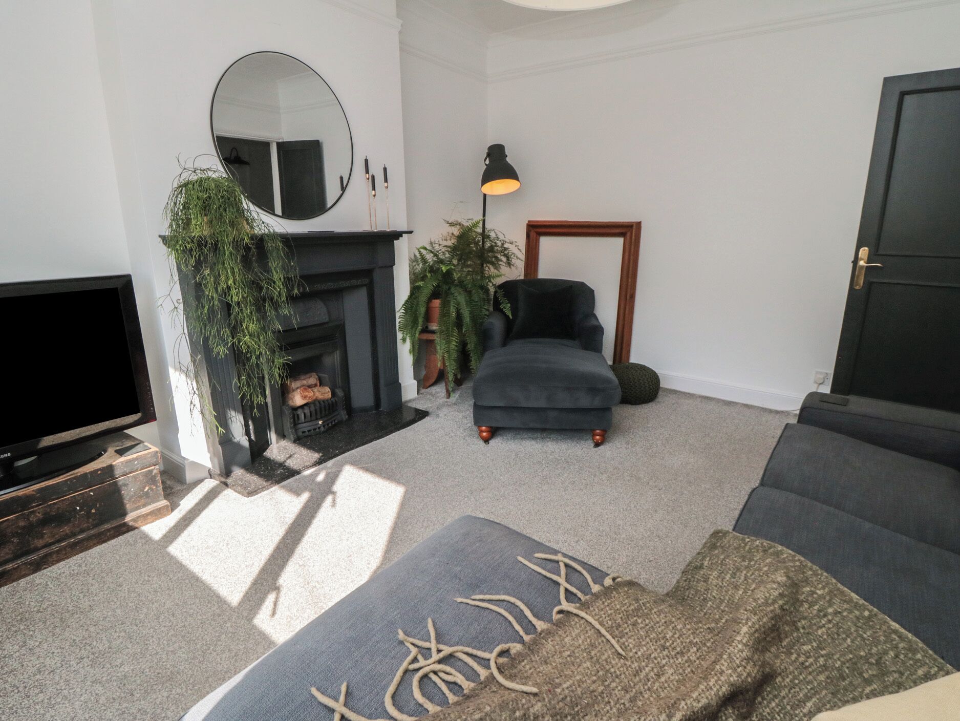 A living room with a fireplace, a television, and a sofa.