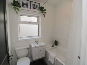 A bathroom with a toilet, sink, and bathtub. - Top-notch Flat (Saltburn-by-the-Sea)