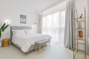 Un dormitorio moderno con cama, mesita de noche, banco y una escalera decorativa con objetos.