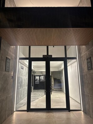 Una entrada moderna a un edificio con un letrero que dice 'PARKON 20'.