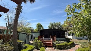 A residential property with a front porch, a small house, and a well-maintained garden. - The Bamboo house on the lake (Hernando)