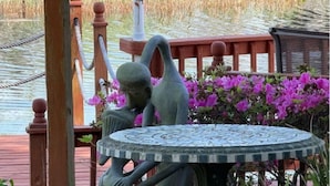 A garden area with a round table and two statues. - The workshop room @ Bamboo house (Hernando)