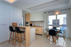 Enjoy meals in this well-designed kitchen and dining area with a central island, bar stools, and a dining table for two.