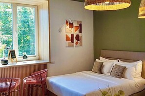 A bedroom with a bed, a desk, two chairs, a window with a view of greenery, and abstract wall art. - 2 Guests, Mountain View, Parking, Near Attractions (Brasov)