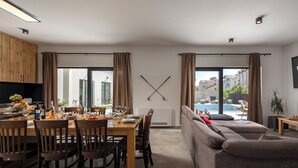 A modern living room with a dining area, large windows, and a view of a swimming pool. - Villa Claudio with private Pool, Vodice, Croatia (Vodice)