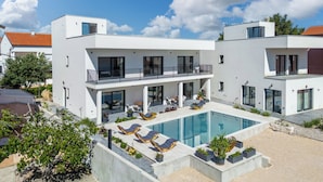 A modern two-story house with a swimming pool, outdoor seating, and a balcony. - Villa Claudio with private Pool, Vodice, Croatia (Vodice)