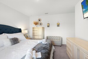Ein Schlafzimmer mit Bett, Nachttisch, Kommode und Stuhl.