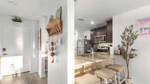 Una cocina moderna con una isla central, taburetes de bar y una planta en maceta.