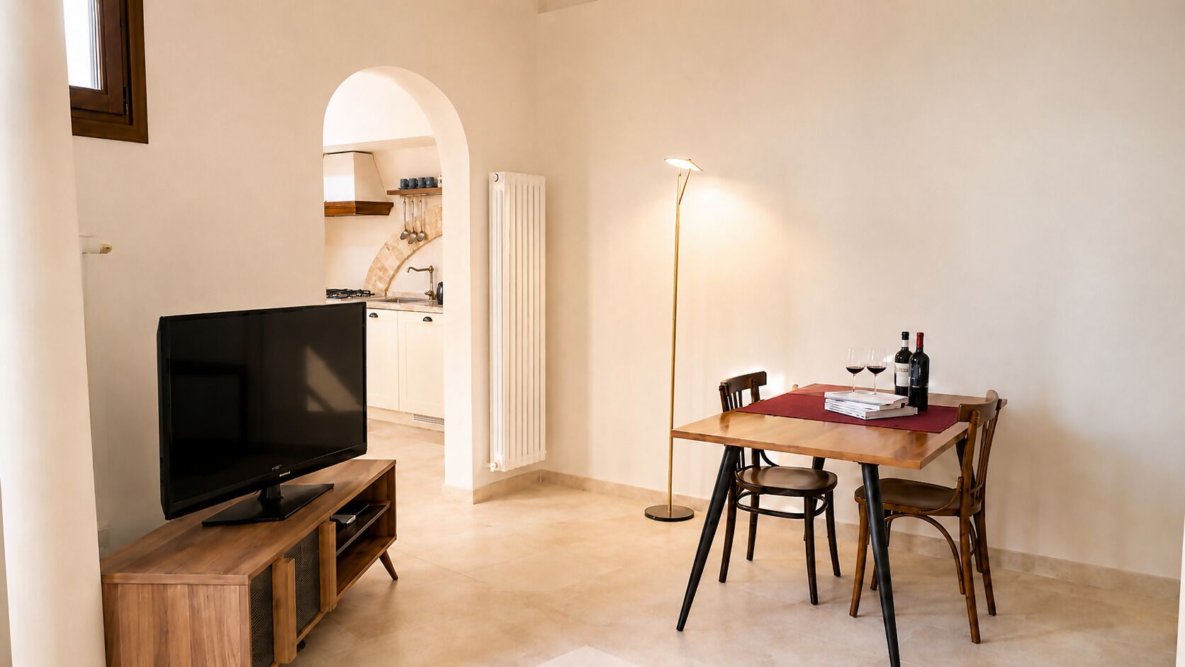 Un salon comprenant un téléviseur, une table à manger, des chaises et un lampadaire.