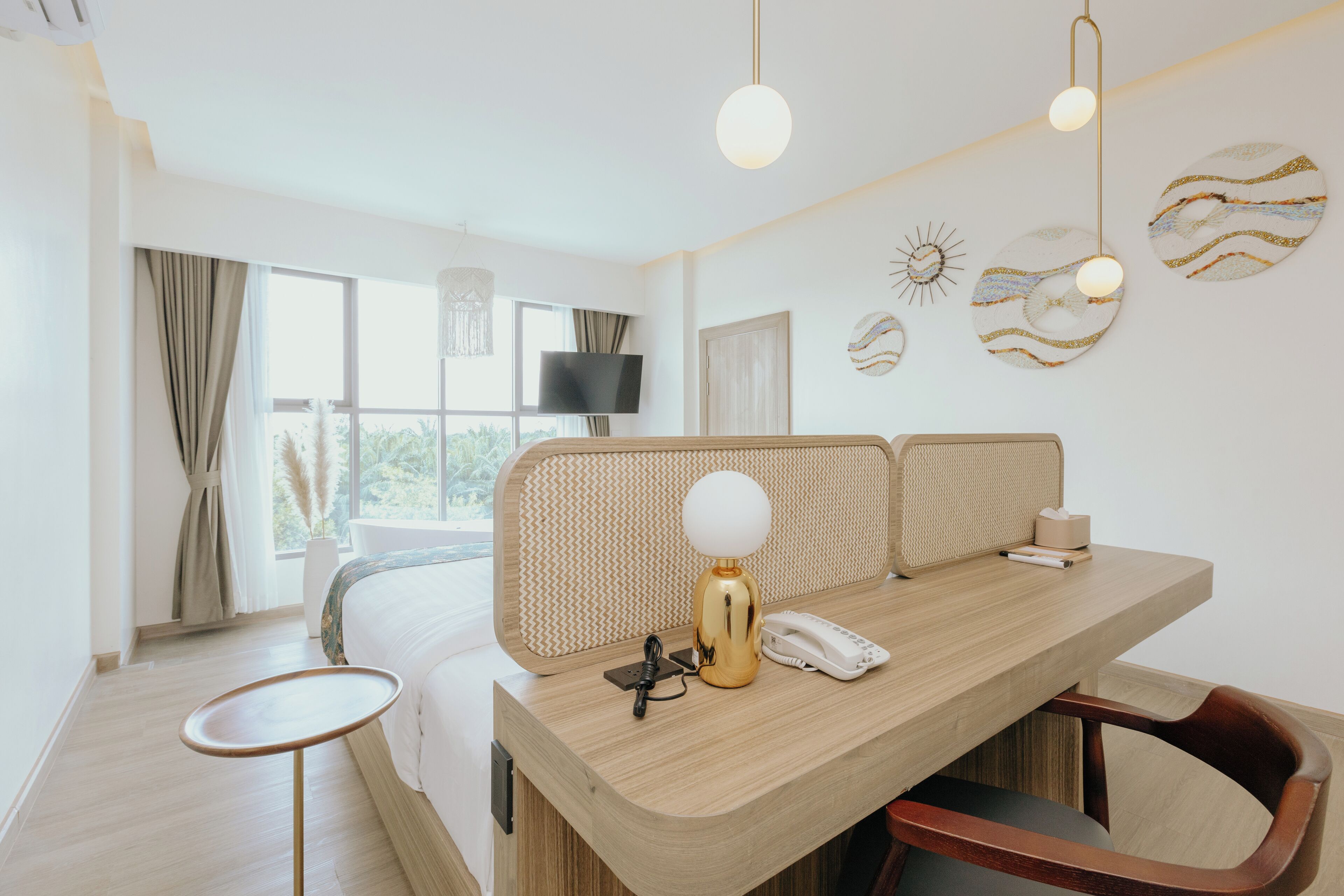 Een moderne hotelkamer met een houten bureau, een stoel, een bed met hoofdeinde, een televisie en decoratieve wandkunst.