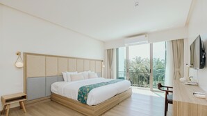 A modern hotel room with a large bed, a desk, a chair, and a TV. - Parima Hotel (Trang)