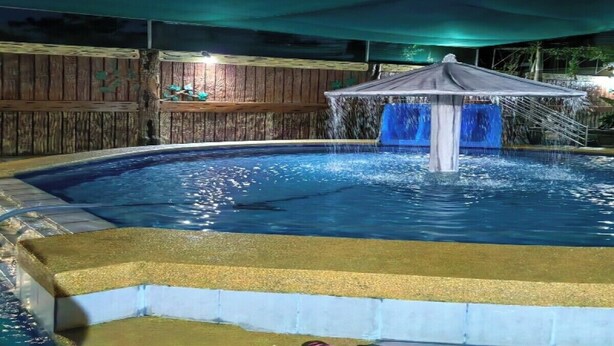 A swimming pool with a fountain and a covered area. - Serene Family Resort with Private Pool Pet Friendly Events and Vacations (Silang)