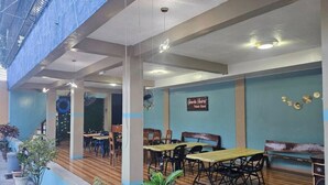 A restaurant with wooden flooring, tables, chairs, and potted plants. - Serene Family Resort with Private Pool Pet Friendly Events and Vacations (Silang)