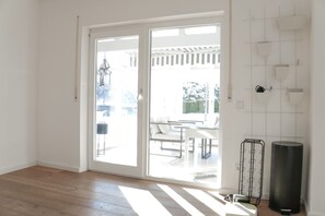 A bright room with a sliding glass door leading to an outdoor patio area. - Holiday Home 'Landhausglück' with Private Terrace, Private Garden and Wi-Fi (Geislingen)