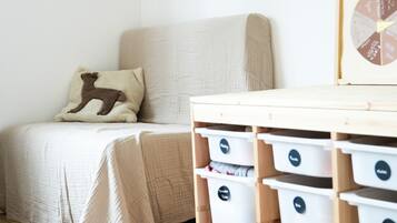 Ein Schlafzimmer mit einem Bett, einem Kissen mit Hirschmuster und Staufässern mit Beschriftungen.