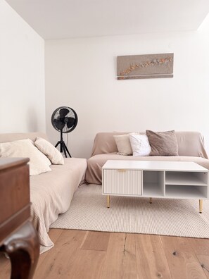 A bedroom with a bed, bedside table, and a standing fan. - Holiday Home 'Landhausglück' with Private Terrace, Private Garden and Wi-Fi (Geislingen)