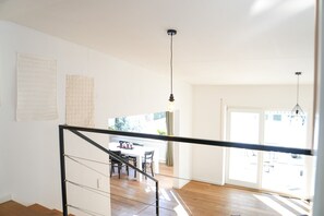 Eine Treppe führt zu einem Essbereich mit Blick ins Freie.
