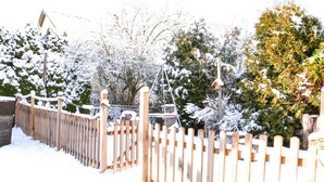 A wooden fence with snow accumulation, surrounded by trees and a birdhouse. - Holiday Home 'Happiness' with Private Terrace, Private Garden and Wi-Fi (Geislingen)