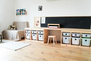 A child's room with a wooden desk, storage bins, a bed, and a chalkboard. - Holiday Home 'Landhausglück' with Private Terrace, Private Garden and Wi-Fi (Geislingen)