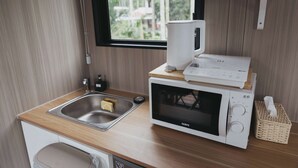 Une cuisine compacte équipée d’un four à micro-ondes, d’un grille-pain et d’un évier.