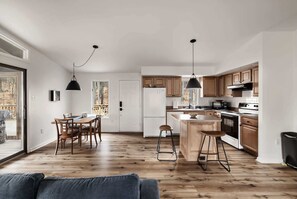 A modern kitchen with wooden cabinets, a central island, and pendant lighting. - Cozy cabin w/deck & grill, dog-friendly, trails (Berkeley Springs)