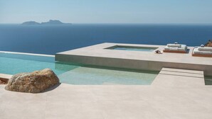 A modern infinity pool with a clear view of the ocean and a distant island. - Keras Cliff House, Keras Cliff House | Sanctuary Above the Sea (Τοπική Κοινότητα Αγίας Γαλήνης)